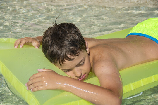 Young boy relaxing on an inflatable mattress in the sea