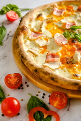 Appetizing, fresh pizza is on the table. Food from an Italian restaurant. Cooking pizza. Pizza ingredients.