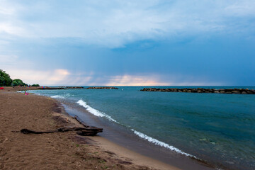 Fototapeta premium Looking out on Lake Ontario from an empty beach after a morning rain storm has pasted. Shot in Toronto's Beaches neighbourhood shot in mid June