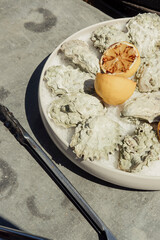 A platter of oysters with grilled lemons