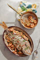 Platter of creole style red snapper on a kitchen counter