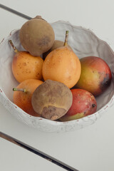 Bowl of tropical fruit including passion fruit and mango