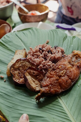 Rice and beans and fried fish on a banana leaf plate