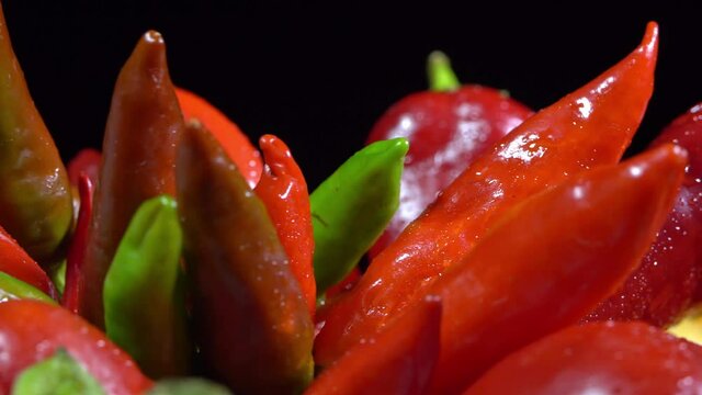Vegetarian healthy food, composition of vegetables,  rotation of a basket with peppers on a black background