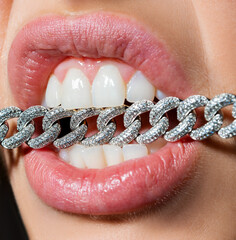 Aggression woman with chain in teeth close up . People and aggression concept close up. Emotional...