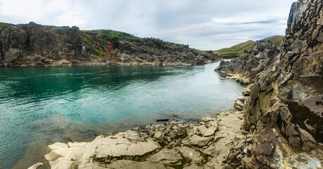 Fototapeta na wymiar Come clear transparent river waters between rocky banks in Iceland. 