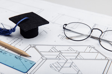 Technical drawings and graduation cap close-up. Engineering education concept