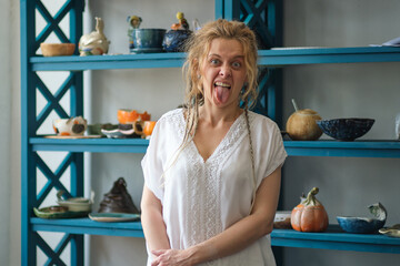 confident business owner posing in her office. in the background a wardrobe with ceramic dishes