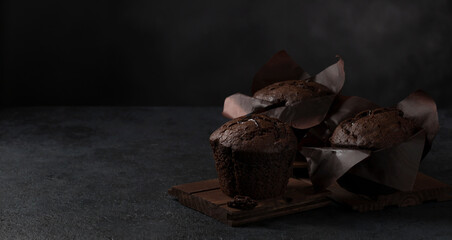 Chocolate coffee delicious muffins on a dark background. Copy space. Selective focus. Low key. Banner