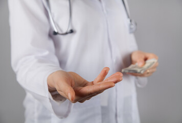 Woman doctor  holding a dollar. Corruption or bribe concept.
