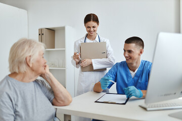 elderly woman patient at doctor's appointment and nurse hospital examination