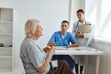 Fototapeta na wymiar male doctor with a nurse examining an elderly woman
