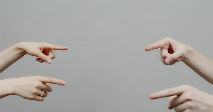 Four hands from different sides point their fingers to the center