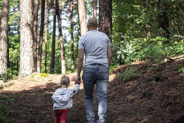 Tata z synem na spacerze w lesie.