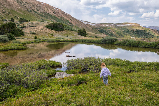 Young girl in front of an alpine lake, Colorado