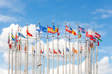 Group of flags of European countries waves against blue sky with few clouds. Global business and communications. Sports competition. International relations theme.
