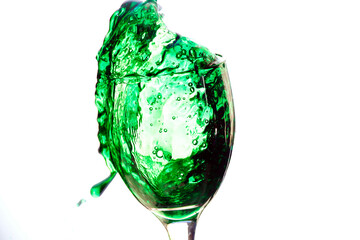 Taça de cristal  transbordando liquido verde.
