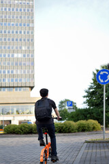 Cyclist and traffic rules. A cyclist rides through the city and approaches roundabout with a road sign.