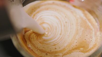 Milk being poured into fresh coffee