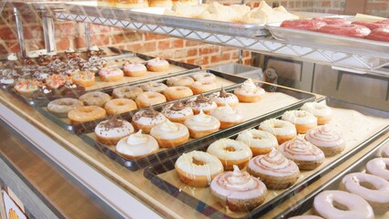 Fresh donuts on display behind glass 1