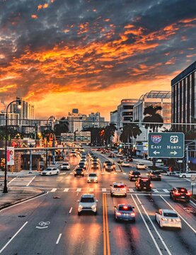 traffic in the city at sunset Biscayne bulevar miami Florida cars lights reflections sky clouds building palms people road street  