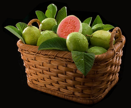 Goiabas na cesta de vime em fundo preto isolado.