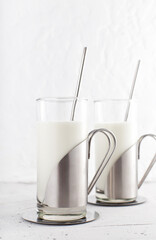 Traditional indian drink in glass with steel and metal straw. Lassi made from yogurt with water, spices and ice. Ayran or kefir in design cups