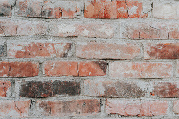 Brick wall in concrete plaster. Textured background of the facade of the old building. The facade is uneven, frayed with cracks. Design element. Copy space