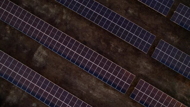 Massive solar plant at sunset. Hundreds of moving solar panels to provide clean energy. Talasol. Drone going forwards and tilting up, revealing the solar plant.
