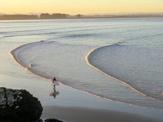 surfer walking on the beach
