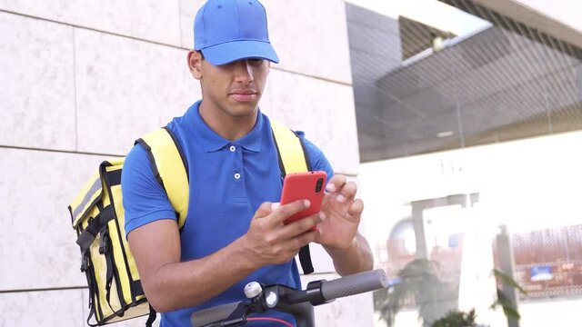 African delivery man using gps smartphone map app for food order riding electric scooter - Focus on courier man face