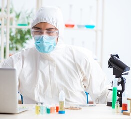 Male biochemist working in the lab on plants