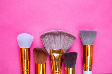 BROCHAS PARA MAQUILLAJE DORADAS SOBRE FONDO ROSA