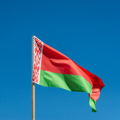 Waving flag of Belarus against the blue sky.