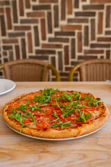 Italian pizza with herbs on a wooden table