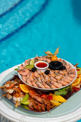 Seafood at a luxury resort overlooking the pool. Shrimp, lobster, crabs, fruit, crane sauce, soy sauce.