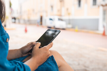 woman sitting in the park looking at the cell phone smiling