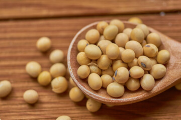 Macro shot of soybeans in wooden spoon. Vegan food concept
