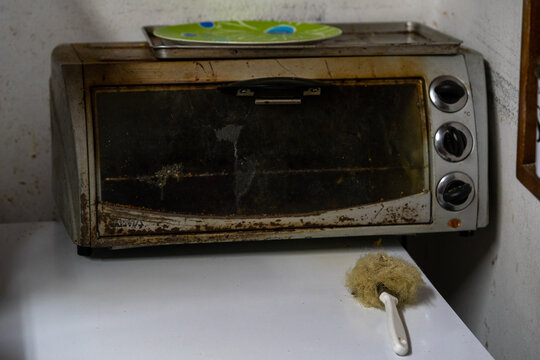 Old Dirty Burnt Microwave Oven On The Table