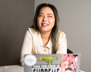 Young Asian Data Scientist Laughing at a Meeting