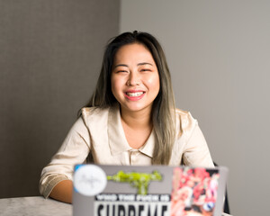 Young Asian Data Scientist Laughing at a Meeting