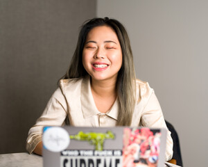 Young Asian Data Scientist Laughing at a Meeting