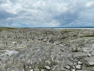Rocky shore in a cloudy landscape. Seashore at low tide.
