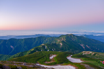 日の出前の白山御前峰山頂から眺める別山までの雪渓の残る稜線（令和３年７月）