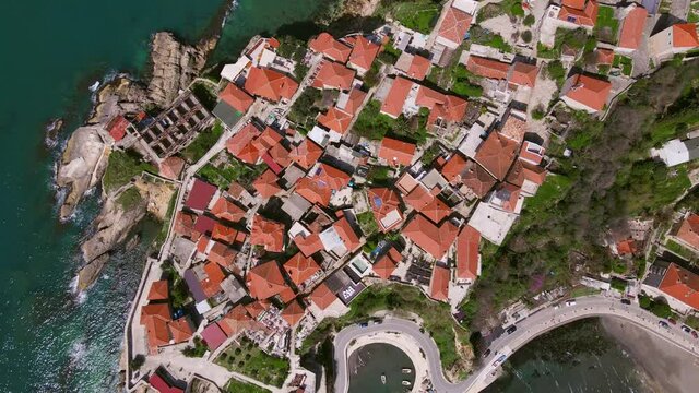Drone with camera circles over magnificent view of old district of the city of Ulcinj, located on the Adriatic coast in Montenegro, slowly descends to ground, top view