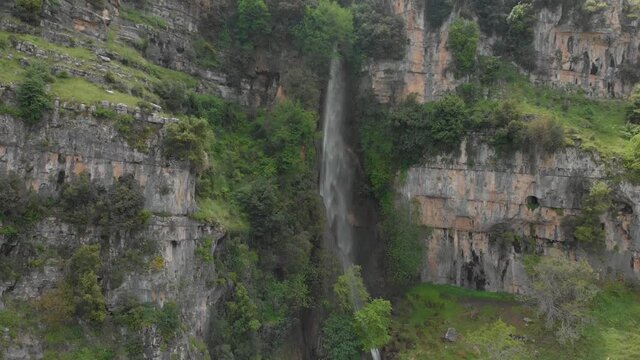 Drone footage flying upward a water fall in old Akkar