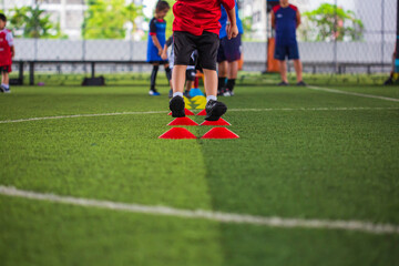 Soccer ball tactics on grass field with barrier for training children jump skill
