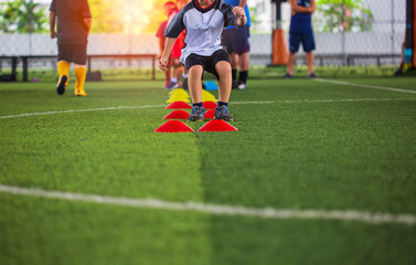 Soccer ball tactics on grass field with barrier for training children jump skill