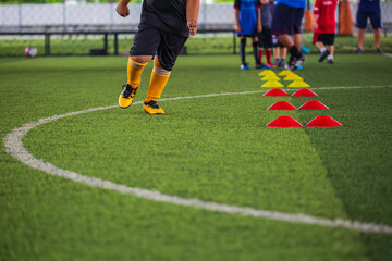 Obraz premium Soccer ball tactics on grass field with barrier for training children jump skill