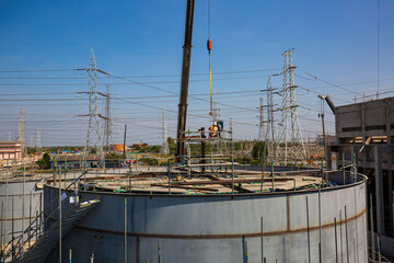 Tank construction site of oil and gas industrial power plant heavy crane lift construction